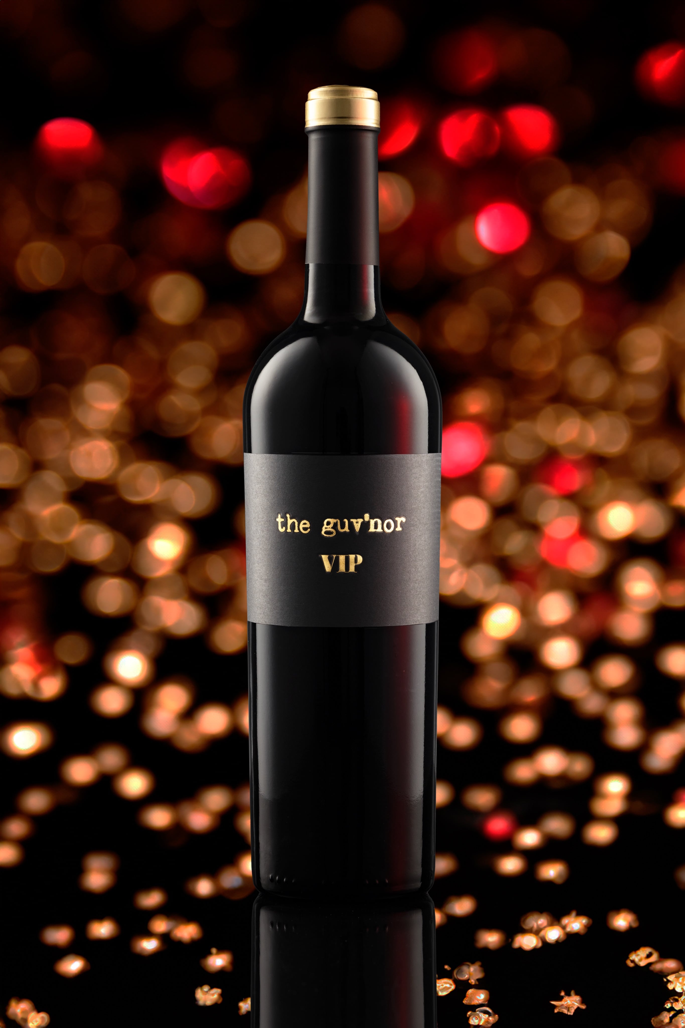 Creative photograph of bottle of guv'nor VIP red wine, with party lights in the background. Creative Wine Bottle Photography by JaxMore Food and Drink Photography, shot in their Derby studio.