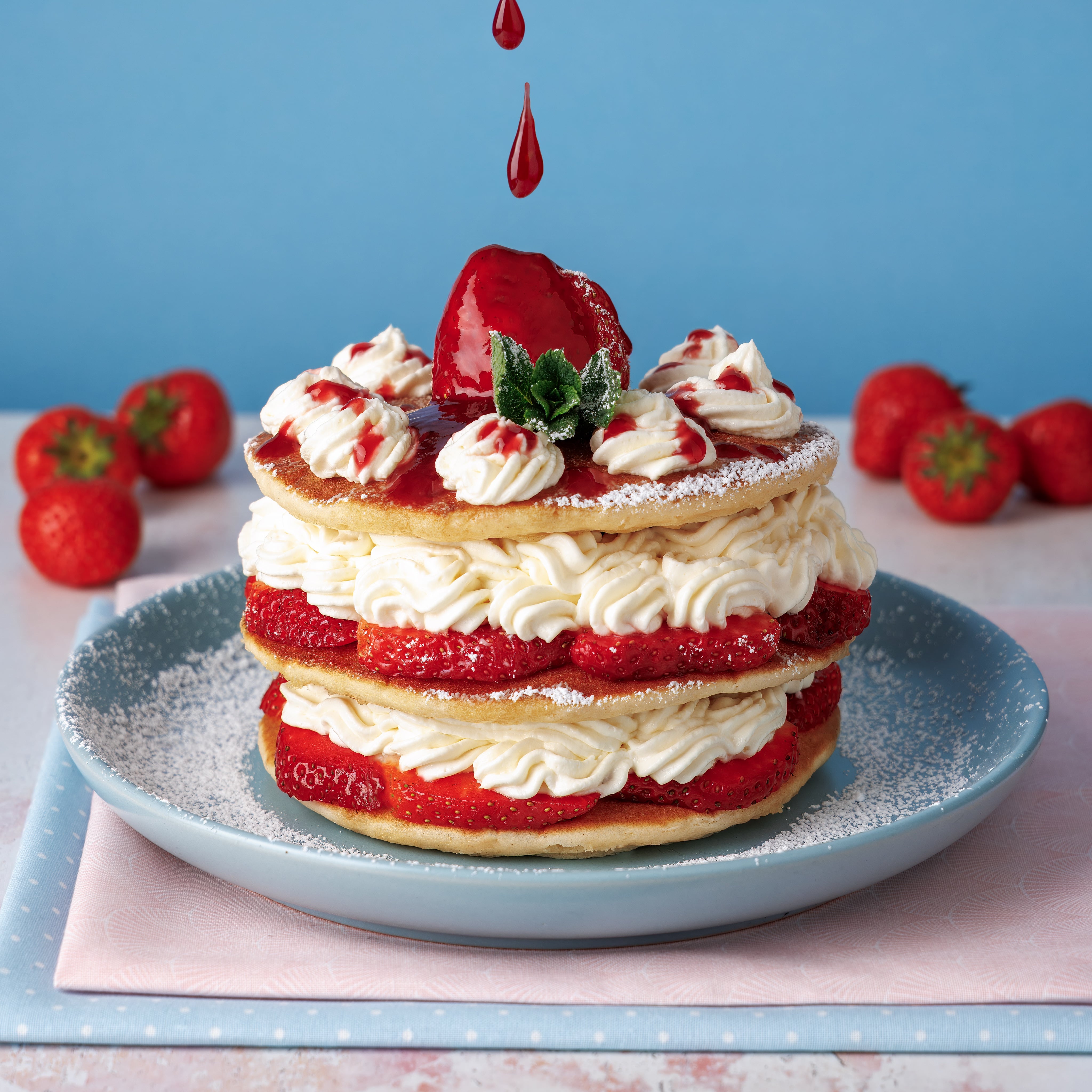 Pancakes, Strawberries and Cream with coulis. Creative Photograph by JaxMore Food and Drink Photography, shot in their Derby studio.