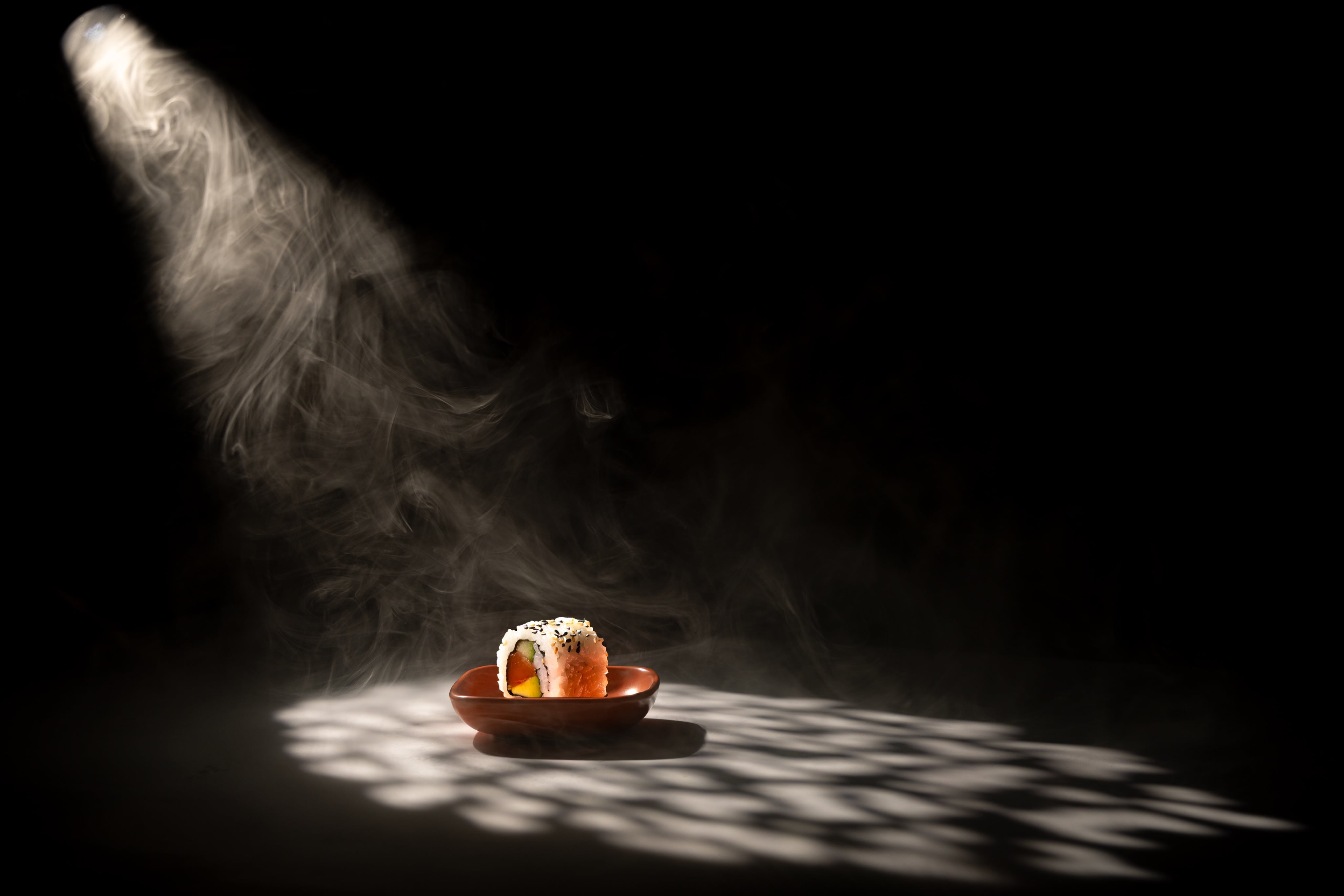 Bringing drama to a California Roll - sushi shot in a striking spotlight. Creative food photograph by JaxMore Food and Drink Photography, shot in their Derby studio.