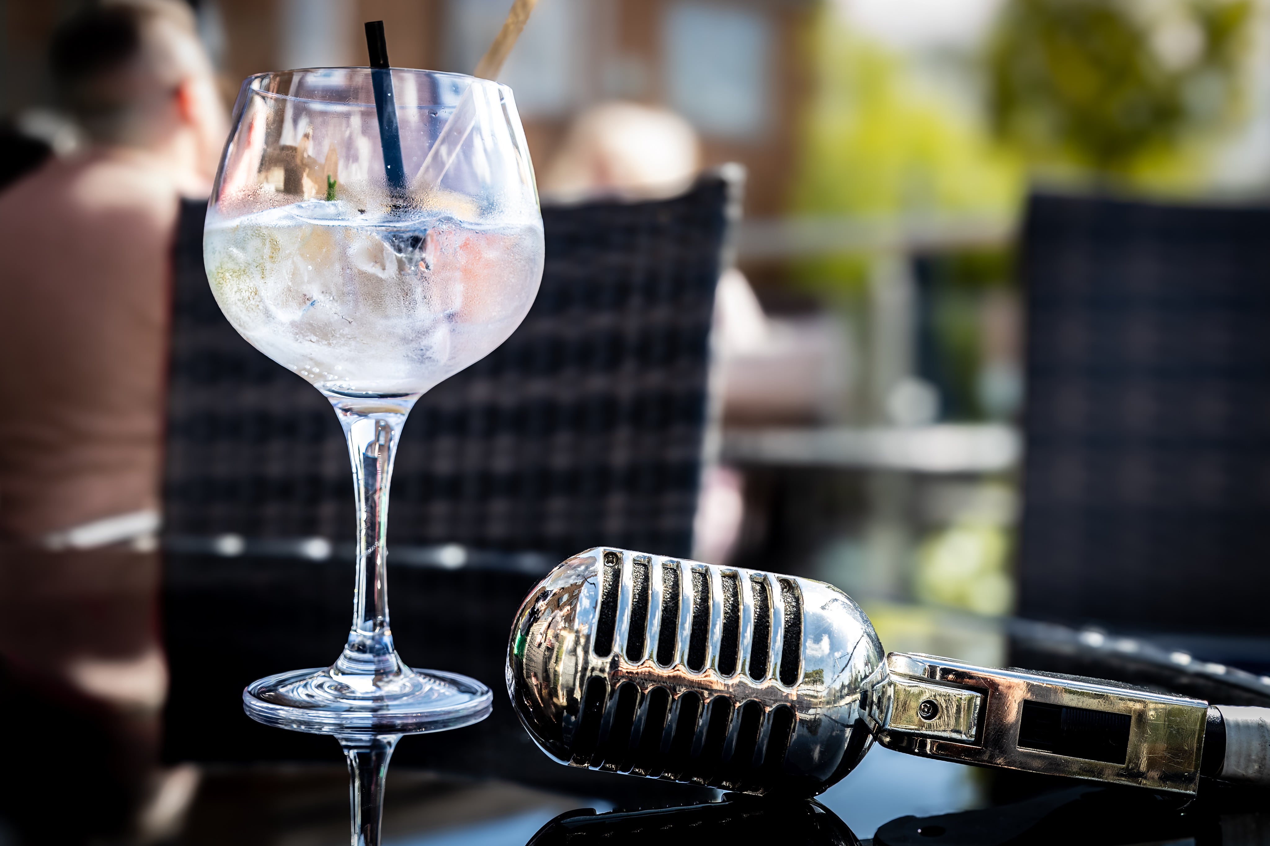 A glass of 'I'll Remember You' Gin, with a 1940s microphone. Premium Drink Photography, shot for Withers Gin by JaxMore Food and Drink Photography, on location at Darley's Restaurant, Derby.
